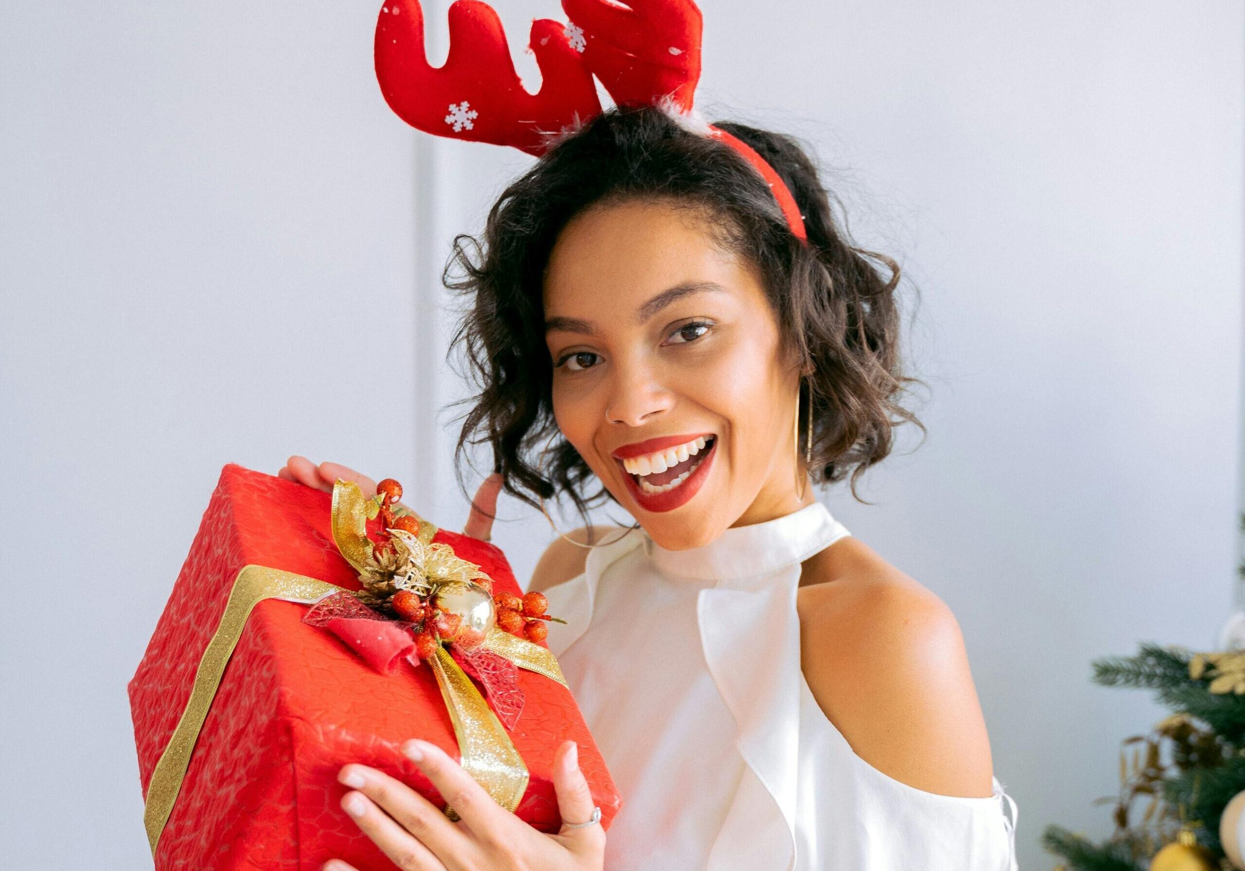 Image of a woman wearing an antler headband and holding a gift.