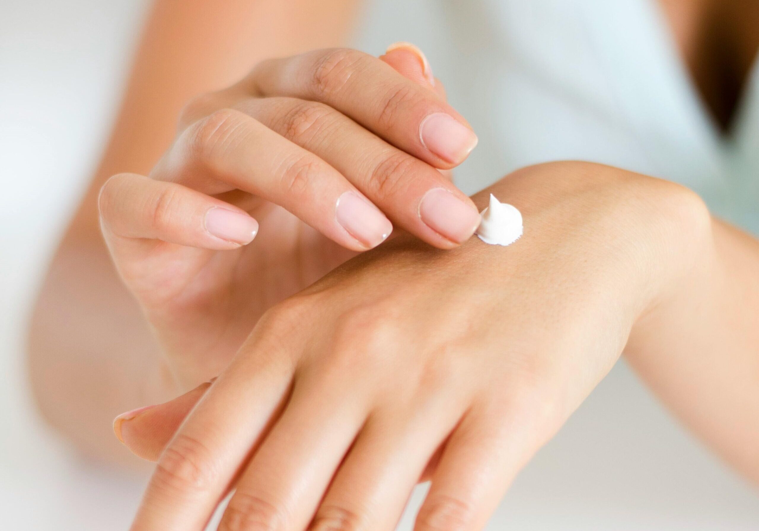 Image of a person putting cream on their hand.